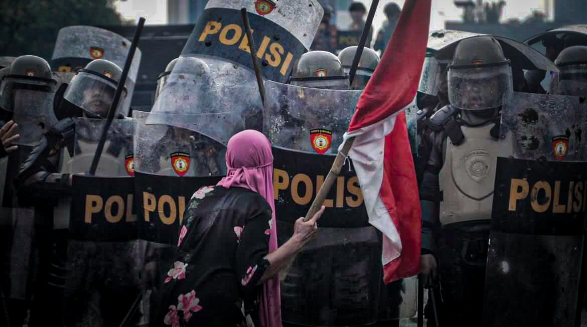Aksi ibu berjilbab pink yang mengibarkan bendera merah putih saat demo tunjangan DPR.