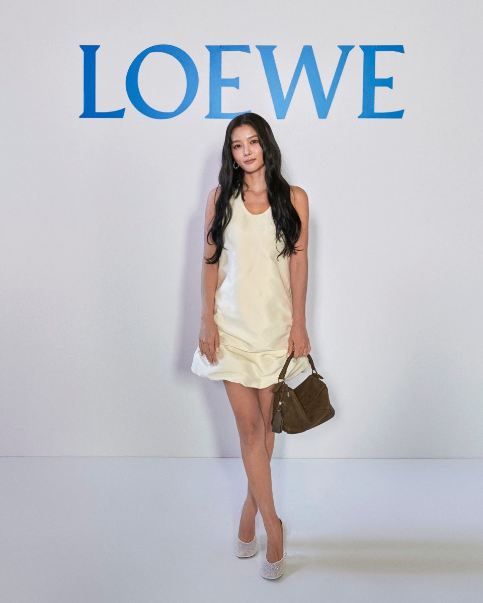 Kim Yoo Jung tampil anggun dengan mini dress satin ivory dan tas suede cokelat di acara Loewe Paris Fashion Week 2025.